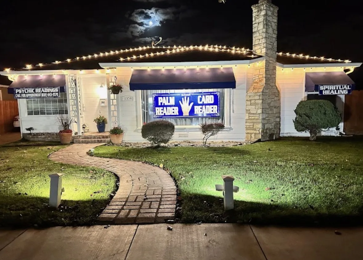 Elaina's reading house at night, glowing with its neon sign